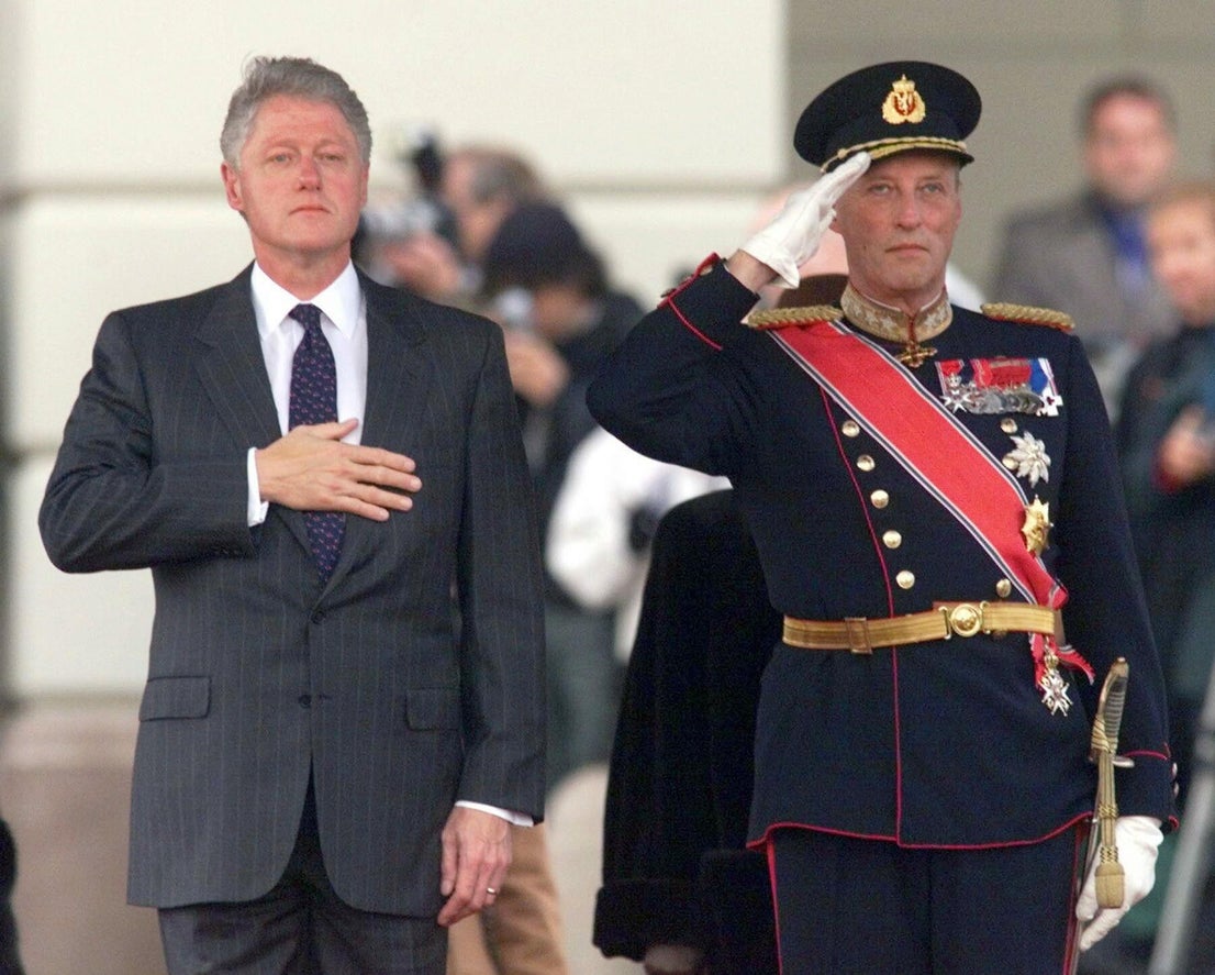 El presidente de los Estados Unidos, Bill Clinton, y el rey Harald de Noruega escuchan los himnos nacionales durante la ceremonia de bienvenida en el Palacio Real de Oslo, el lunes 1 de noviembre de 1999