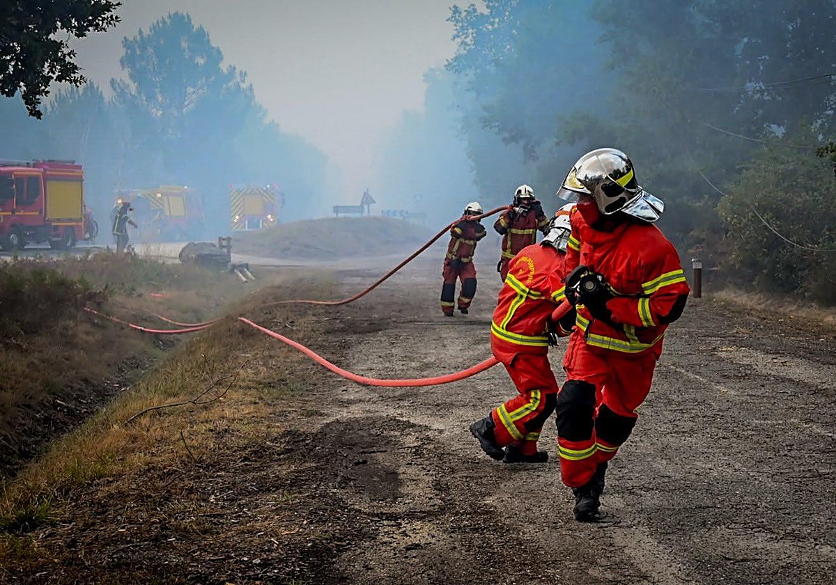 Los bomberos trabajan a escasos kilómetros de Burdeos para crear una barrera contra el incendio.