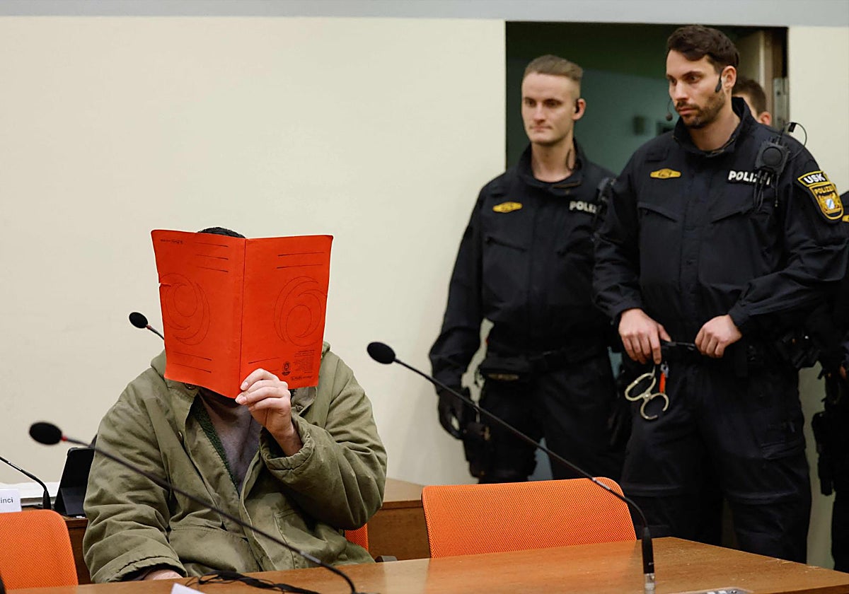 El acusado, Farhad N., se tapa la cara con una carpeta en la sala del tribunal en enero de 2026.