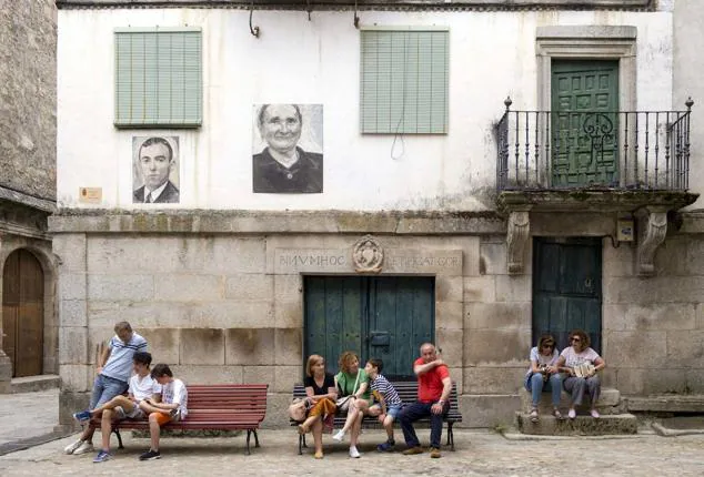 Florencio Maíllo, con el presidente de la Diputación, en una calle de la localidad repleta de retratos.