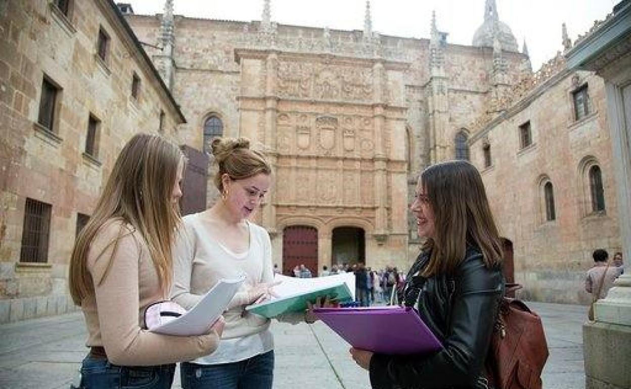 Tres estudiantes frente a la fachada de la Universidad de Salamanca