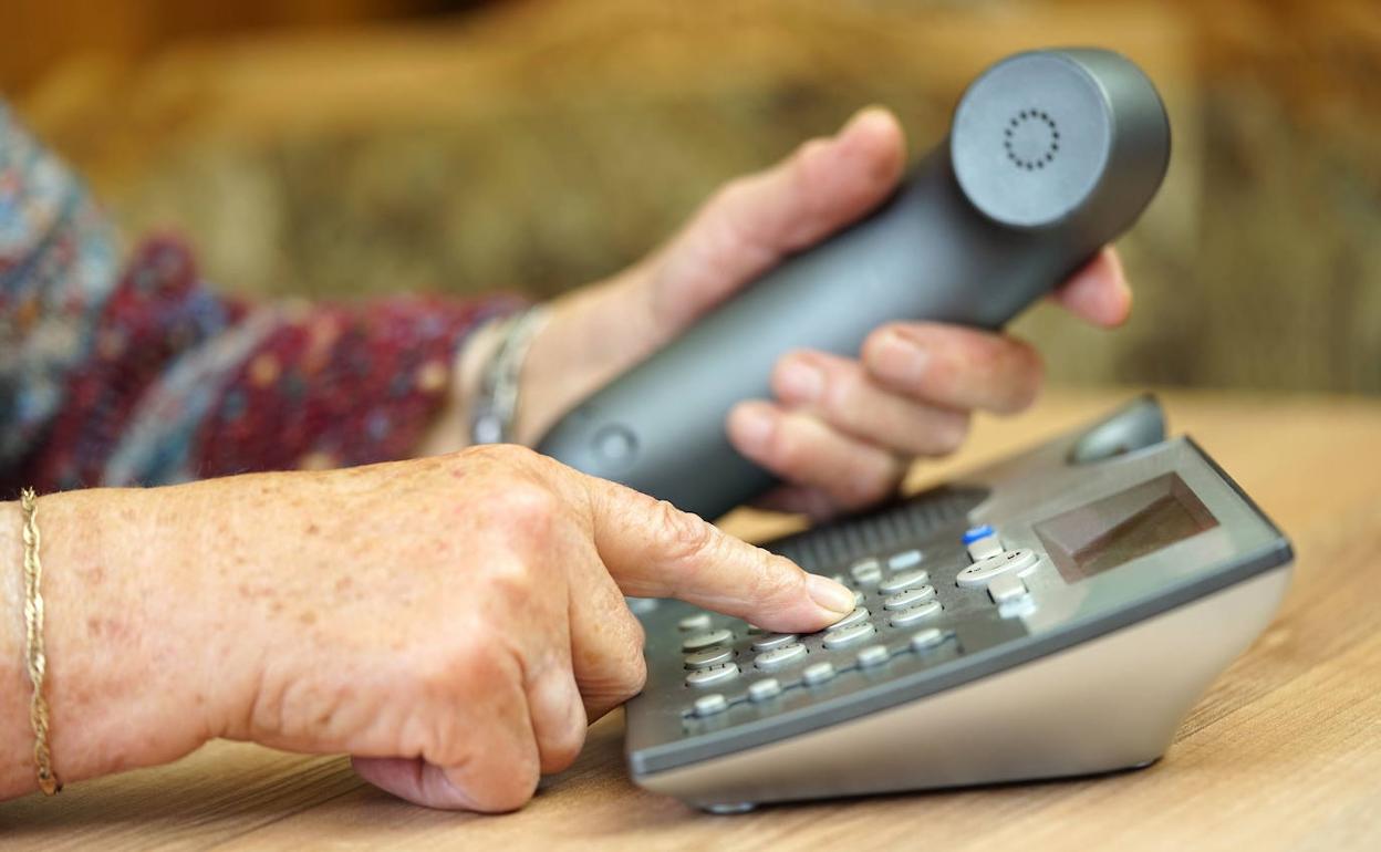 Una mujer marca en un teléfono
