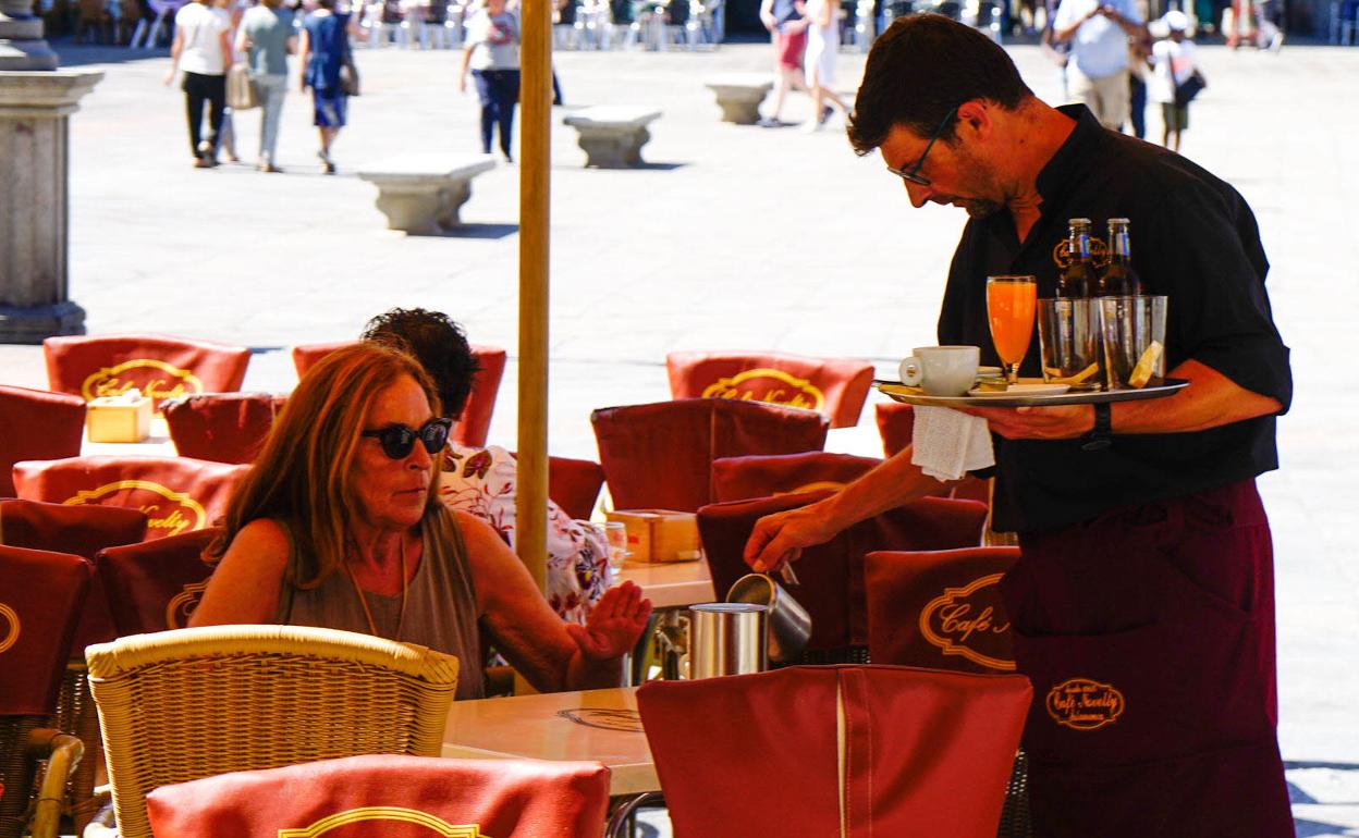 Un camarero sirve un café en la Plaza Mayor de Salamanca. 