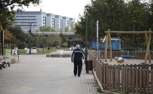 Imagen principal - Una persona en el parque, una de las jaulas y el cartel de paruqe cerrado.