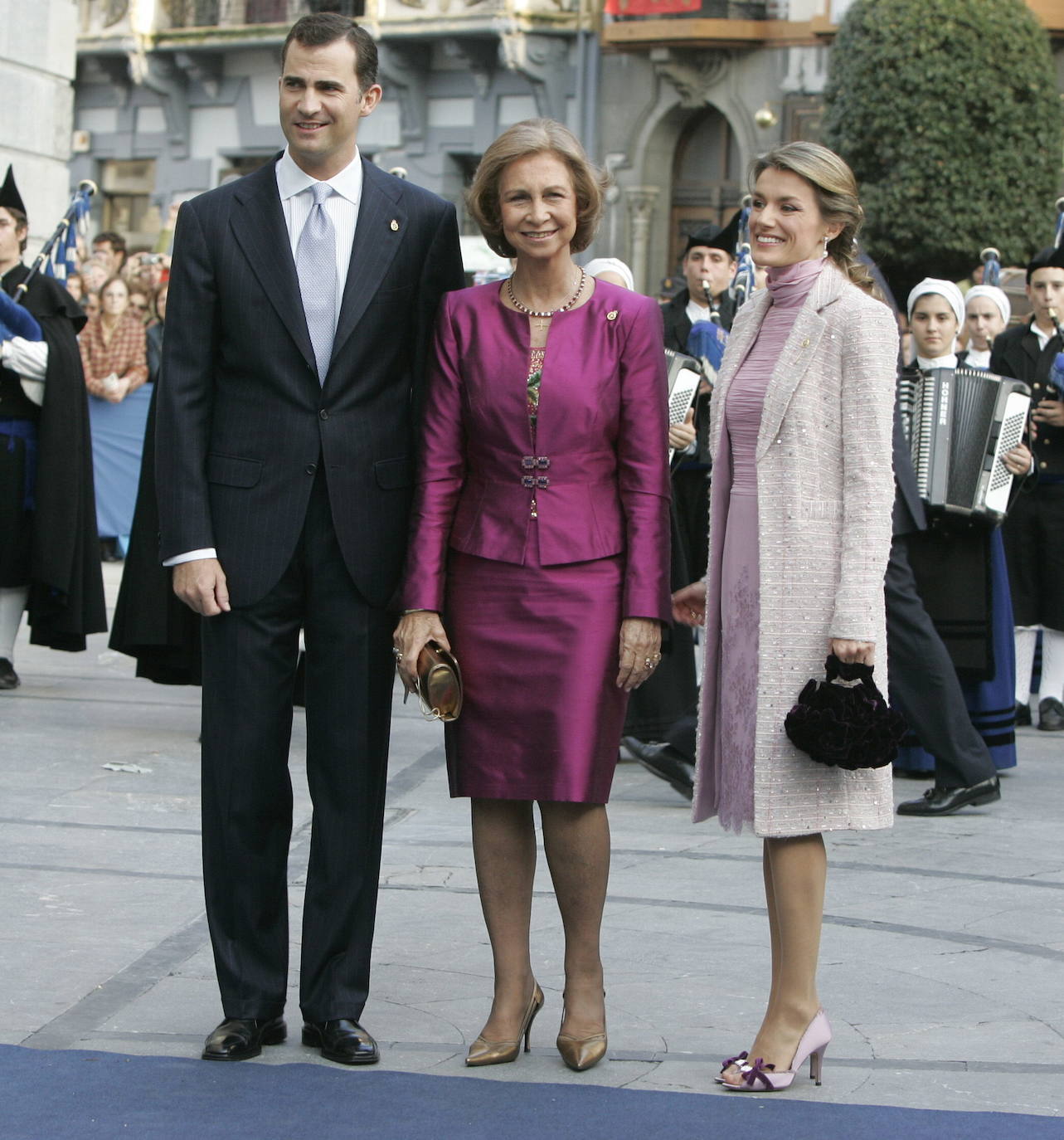 2006. Doña Letizia regresó al Teatro Campoamor tras ausentarse el año anterior por el avanzado estado de gestación de su primera hija, la princesa Leonor. Para su vuelta optó por un vestido con cuerpo drapeado y falda con encaje lila a juego con un abrigo de tweed con hilo brillante. 