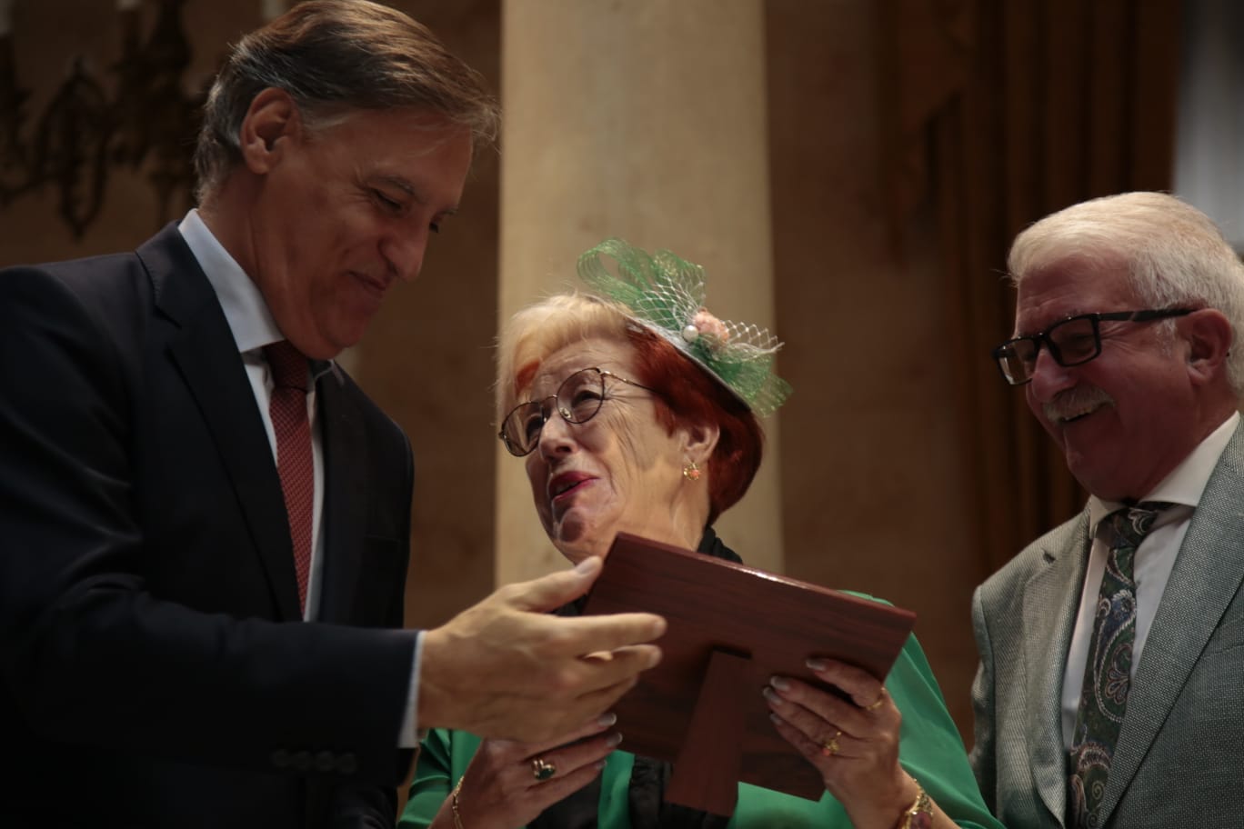 El alcalde de Salamanca entrega una placa a un matrimonio. 