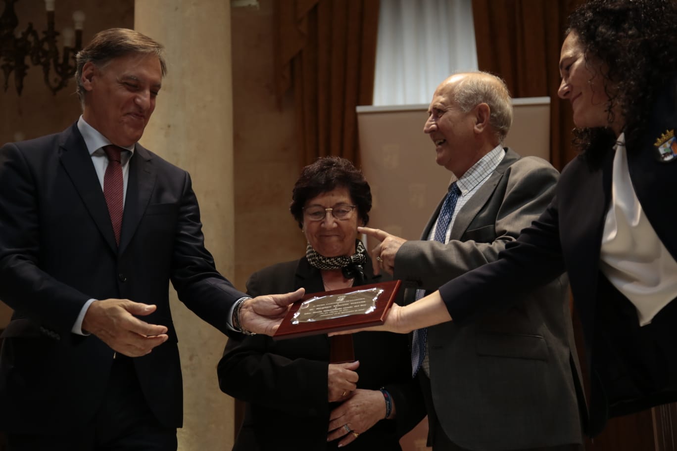 El alcalde de Salamanca entrega una placa a un matrimonio. 