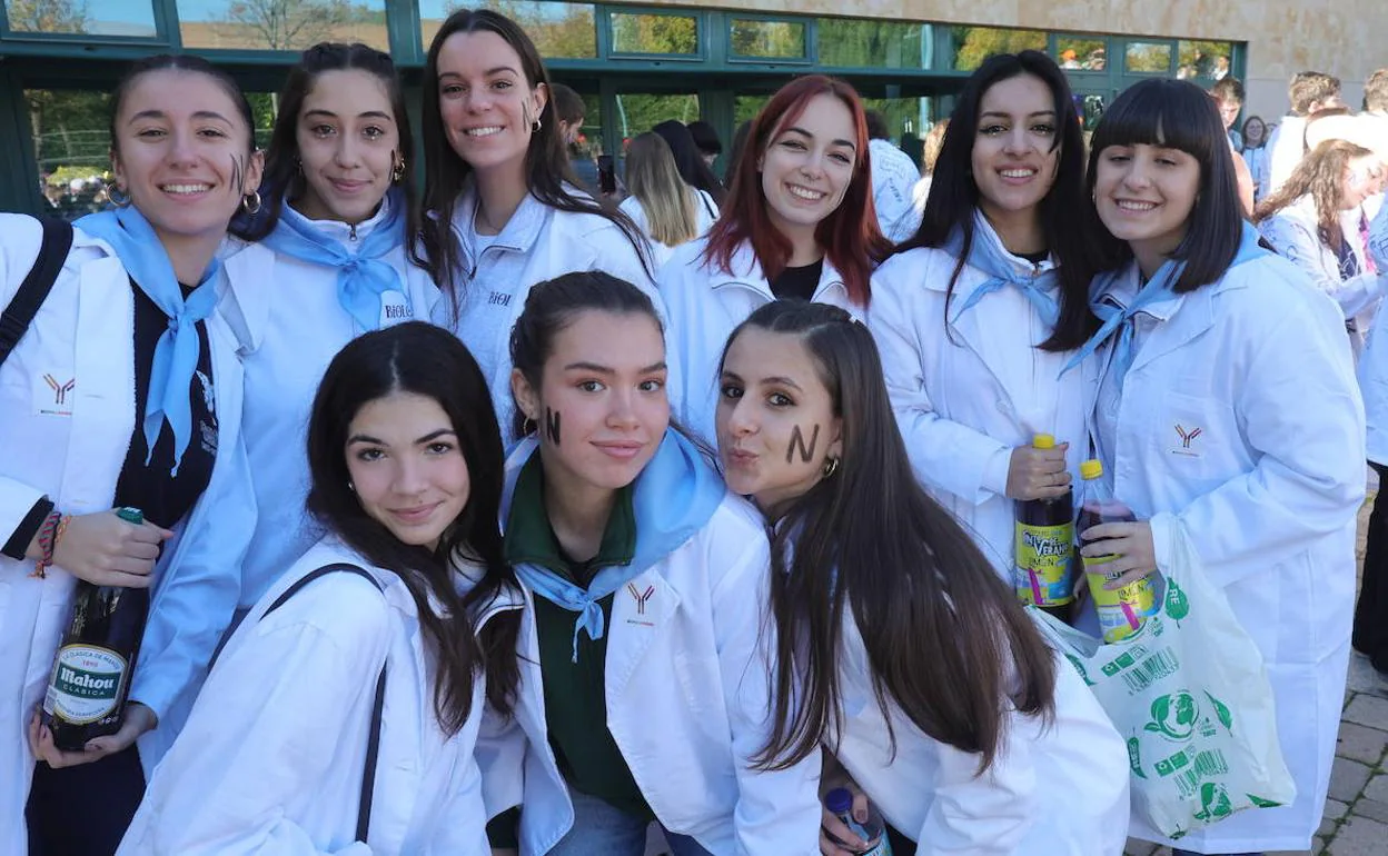 Varios estudiantes posan en el campus junto a la Facultad de Biología. 