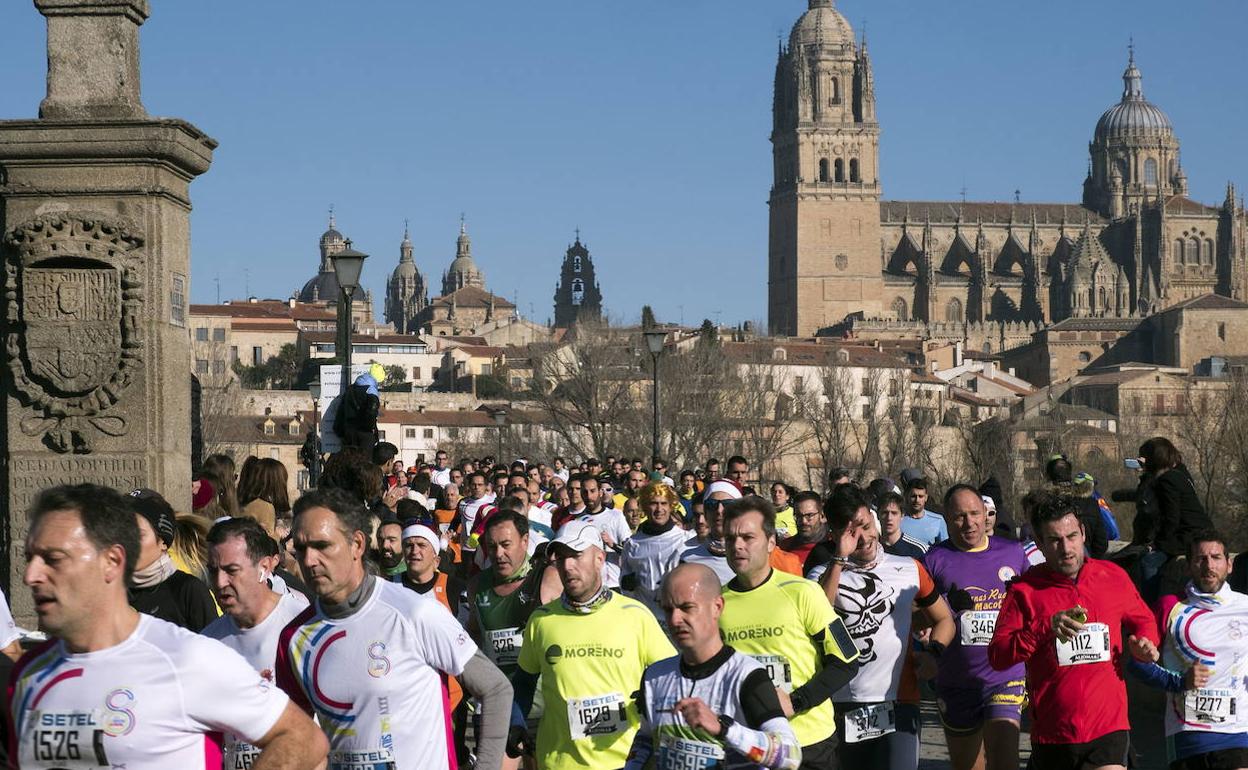 Varios corredores, a su paso por el Puente Romano. 