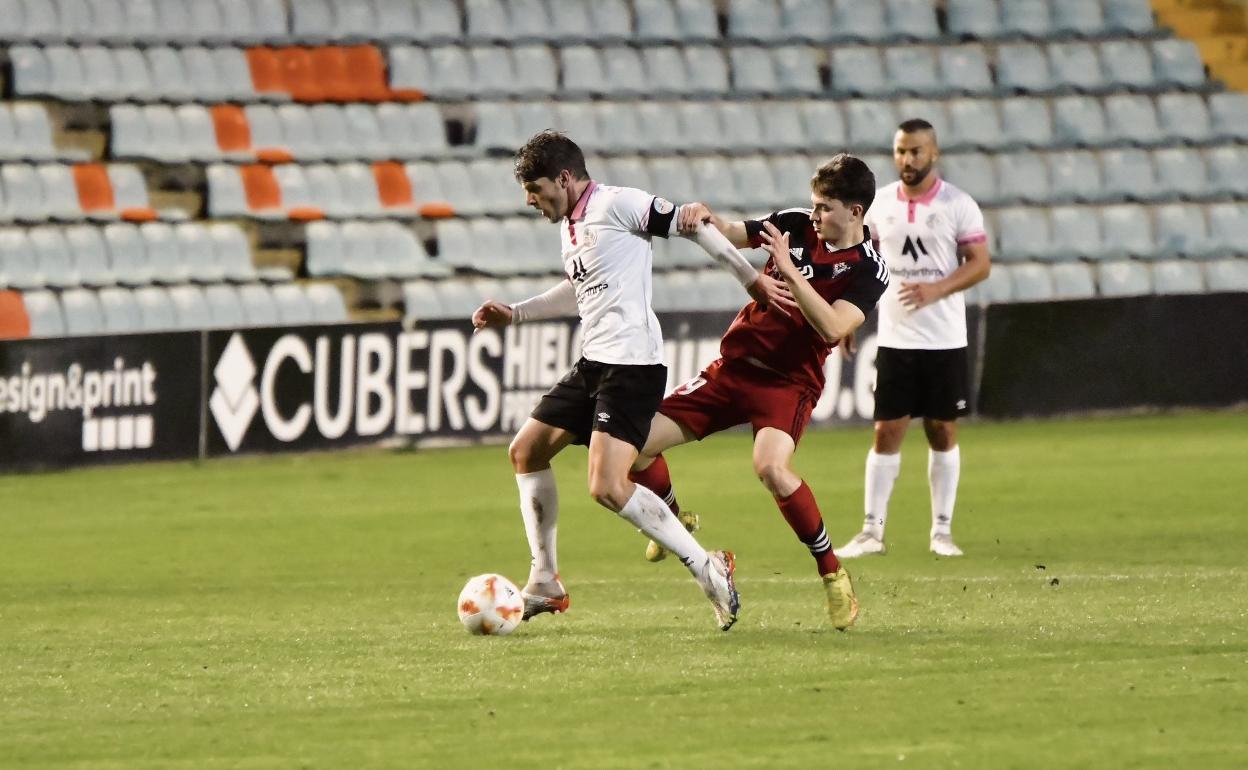 El capitán del equipo, Amaro, conduce el esférico ante la mirada de José Rodríguez 