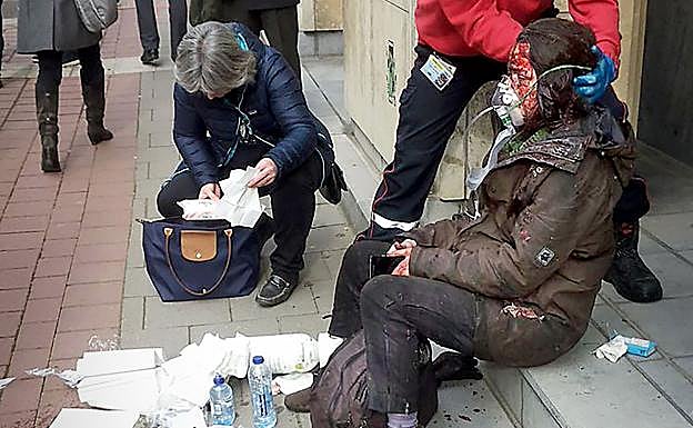 Un agente de seguridad auxilia a una víctima del atentado en el metro de Maalbeek, Bruselas. 