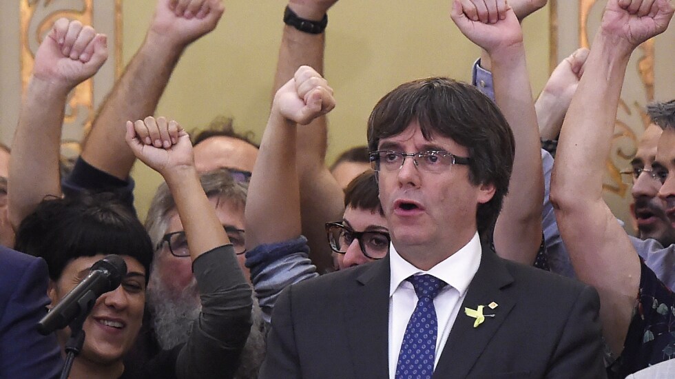 Carles Puigdemont canta «Els Segadors», rodeado de puños de la CUP, tras el pleno en el que proclamó y suspendió la república catalana, con la Declaración Unilateral de Independencia.