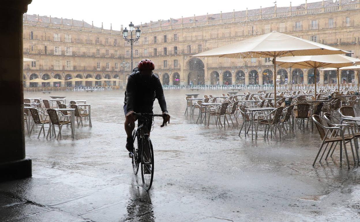 Un ciclista bajo la lluvia en la Plaza Mayor de Salamanca.
