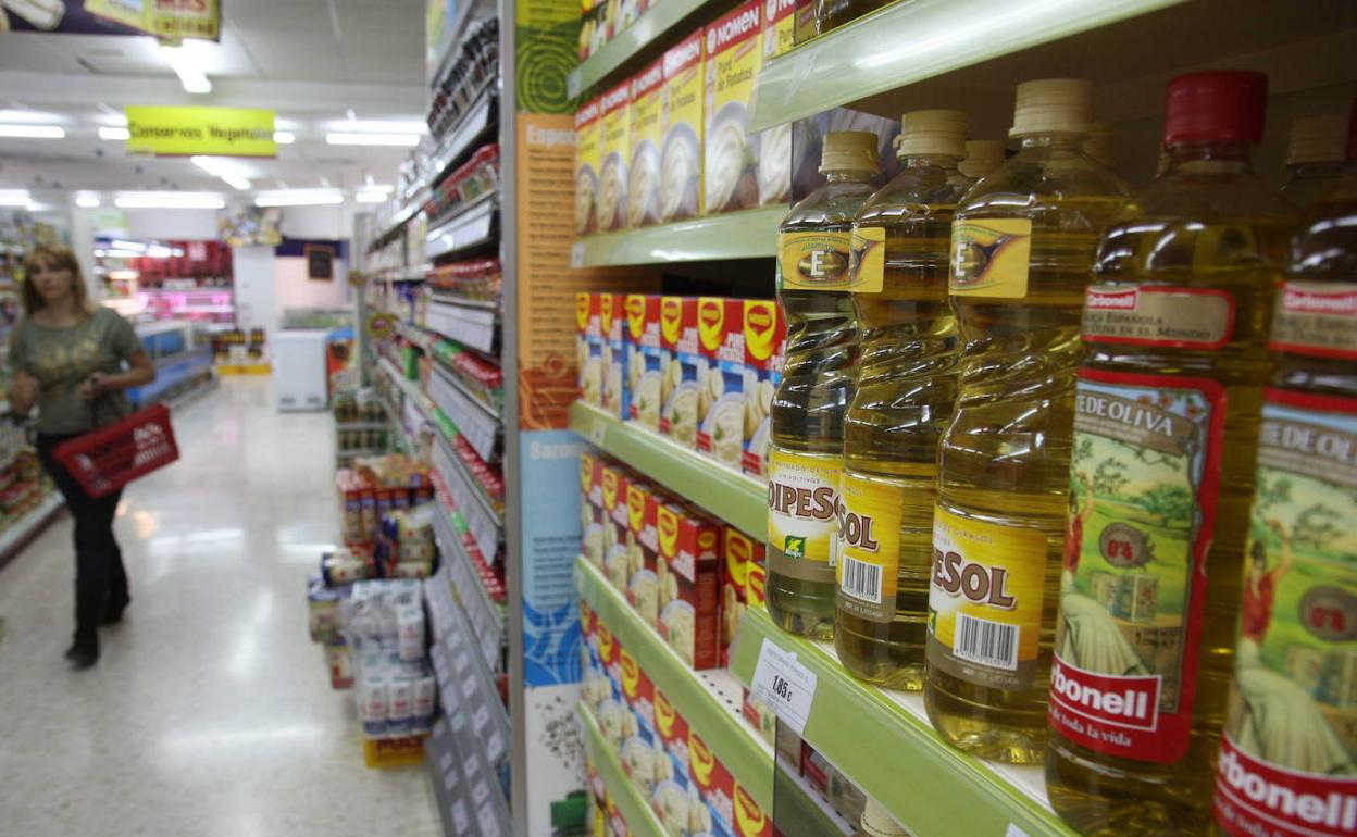 Aceite de oliva y girasol en los estantes de un supermercado. 