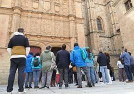 Varios turistas observan la fachada de la Universidad de Salamanca.