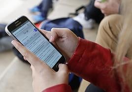Una chica consulta una página web en su teléfono móvil en Salamanca.