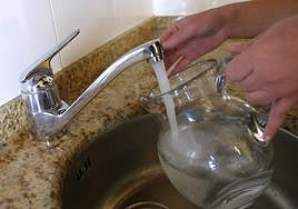 Un usuario rellena de agua una jarra.