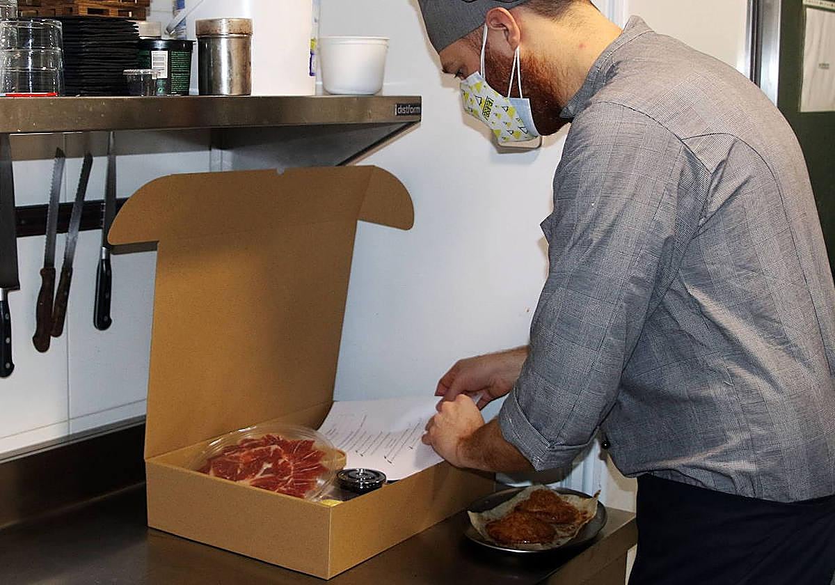 Un empleado prepara un menú completo para enviárselo a un usuario.