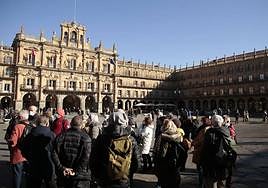 Varios turistas observan la Plaza Mayor de Salamanca.