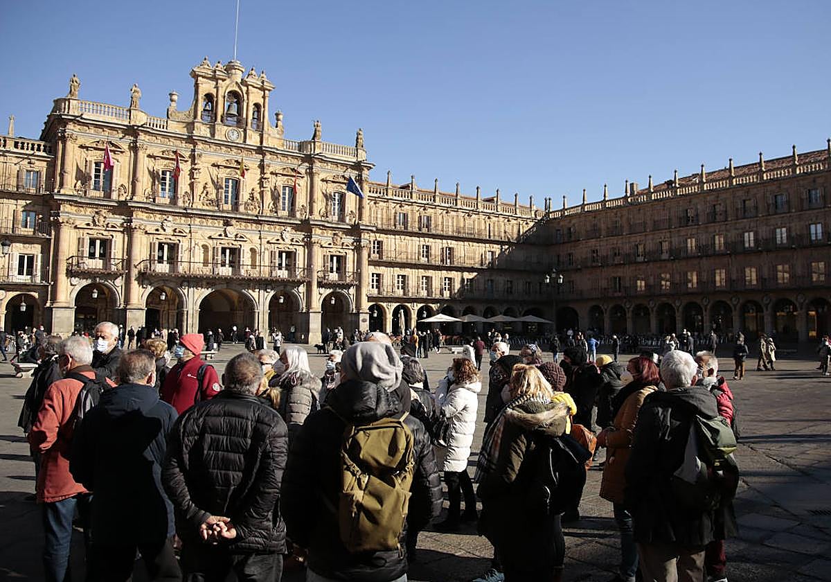 Varios turistas observan la Plaza Mayor de Salamanca.