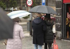 Imagen de archivo de personas bajo la lluvia en Salamanca.