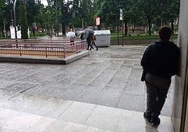 Una persona se resguarda de la lluvia en Salamanca.