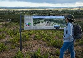 Una turista observa el panel informativo del nuevo sendero.
