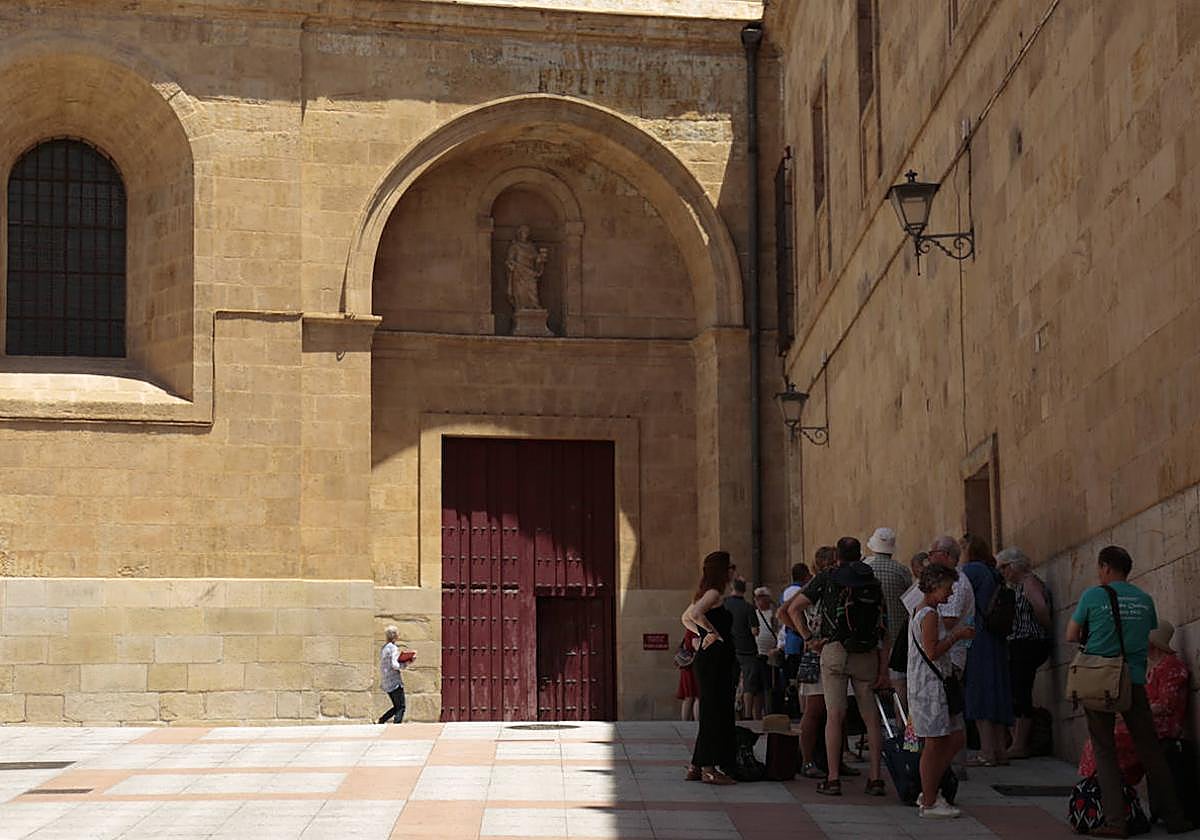Turistas se refugian del calor a la sombra junto a las catedrales de Salamanca.
