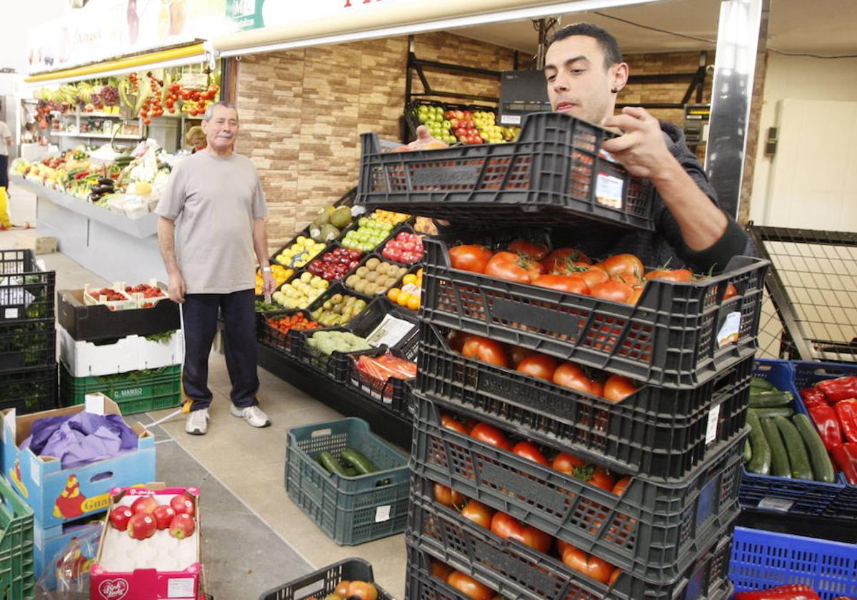 Vendedores de fruta y verdura colocan su mercancía en el Mercado Central de Salamanca.