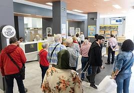 Varias personas esperan en una oficina de Correos.