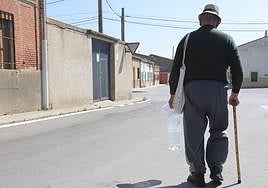 Un hombre carga una garrafa de agua.