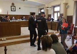 El pistolero de Garrido es conducido por un policía durante la vista en la Audiencia Provincial.