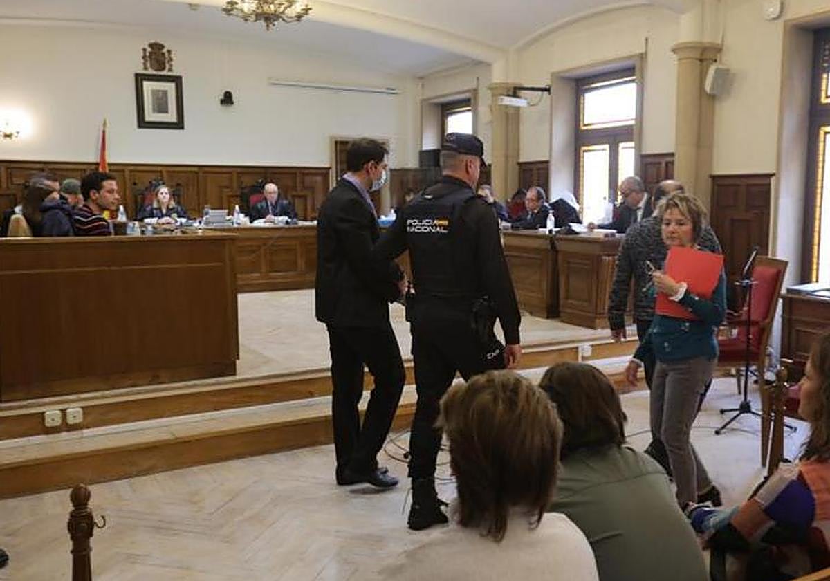 El pistolero de Garrido es conducido por un policía durante la vista en la Audiencia Provincial.