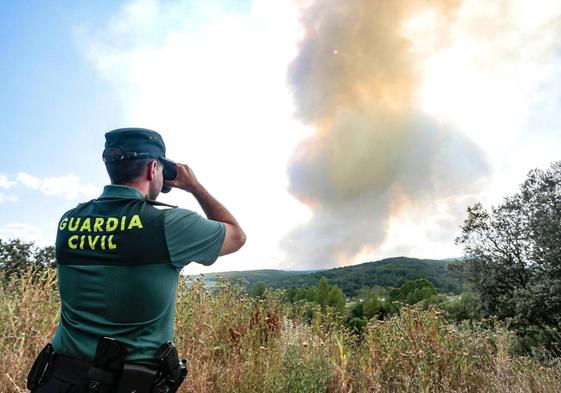 Un agente de la Guardia Civil observa el incendio declarado en León este sábado.