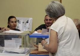 Una mujer desposita su voto en las urnas de Salamanca.