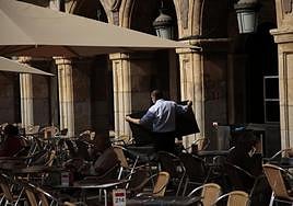 Un camarero recoge un mantel en una terraza de la Plaza Mayor de Salamanca.