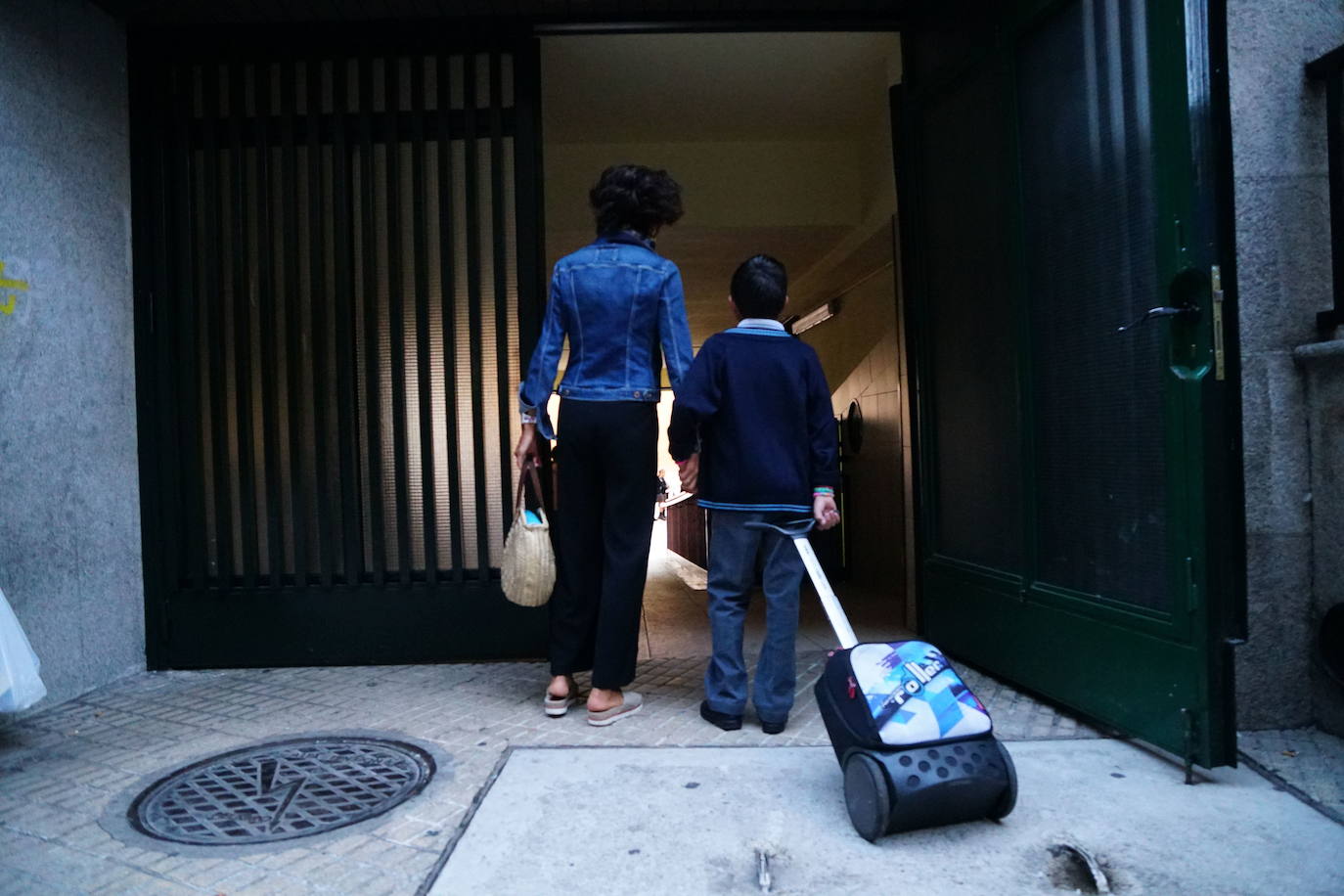 Un niño entrando a la escuela de la mano de su madre en un colegio de Salamanca.