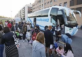 Alumnos se suben a un bus escolar.