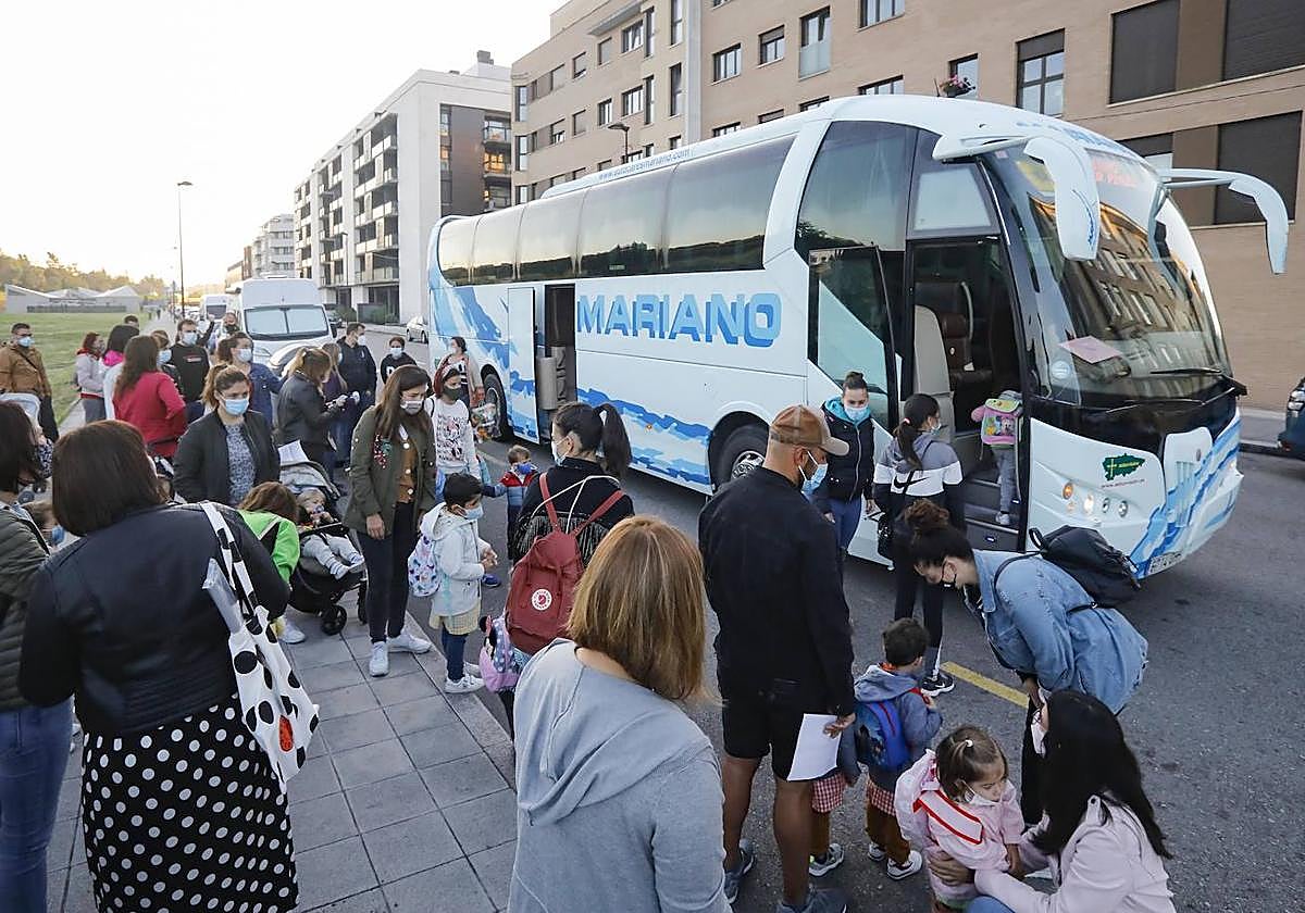 Alumnos se suben a un bus escolar.