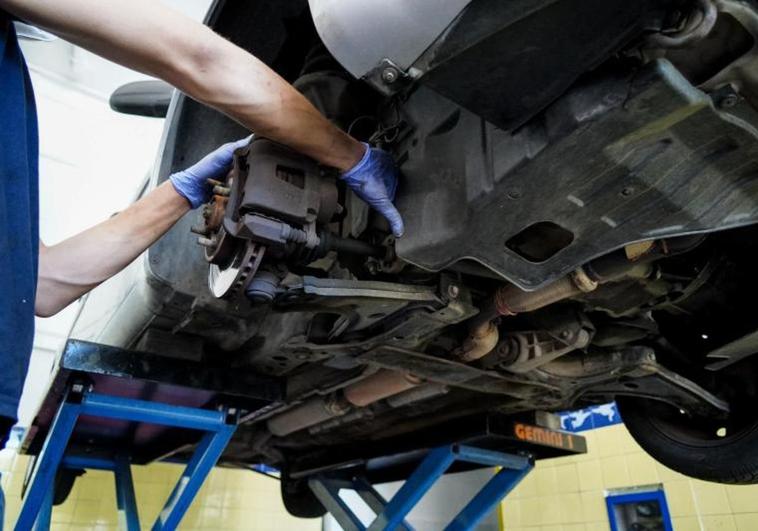Un mecánico repara un automóvil en un taller.