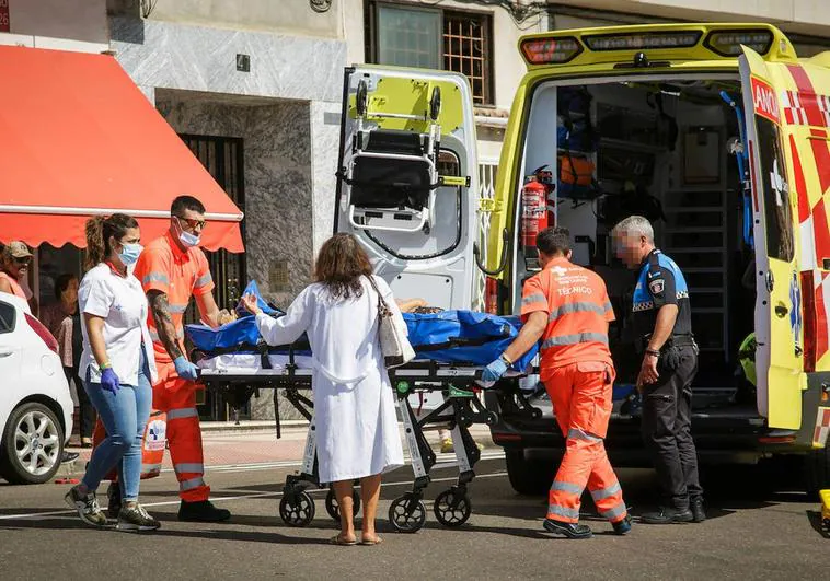 Los servicios de emergencias introducen a la mujer herida en la ambulancia.
