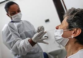 Una enfermera hace un test de antígenos a una mujer.