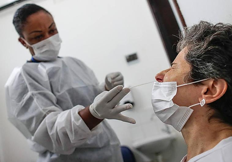 Una enfermera hace un test de antígenos a una mujer.