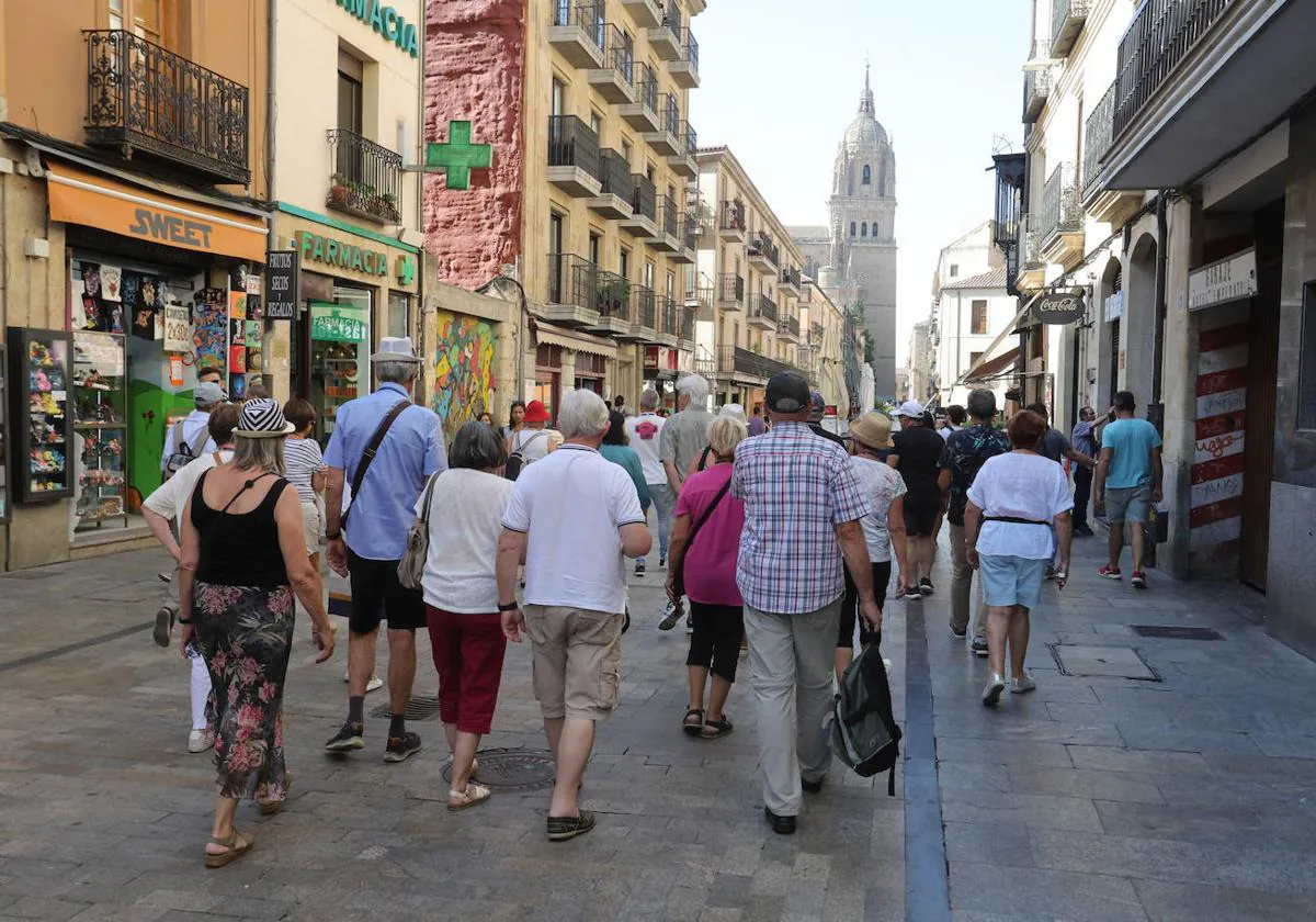 Un grupo de turistas se dirige hacia las catedrales de Salamanca por la Rúa.