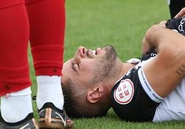 El jugador, tendido en el campo y doliéndose del hombro.