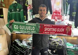 Un seguidor del CD Guijuelo posa con una bufanda conmemorativa del partido.