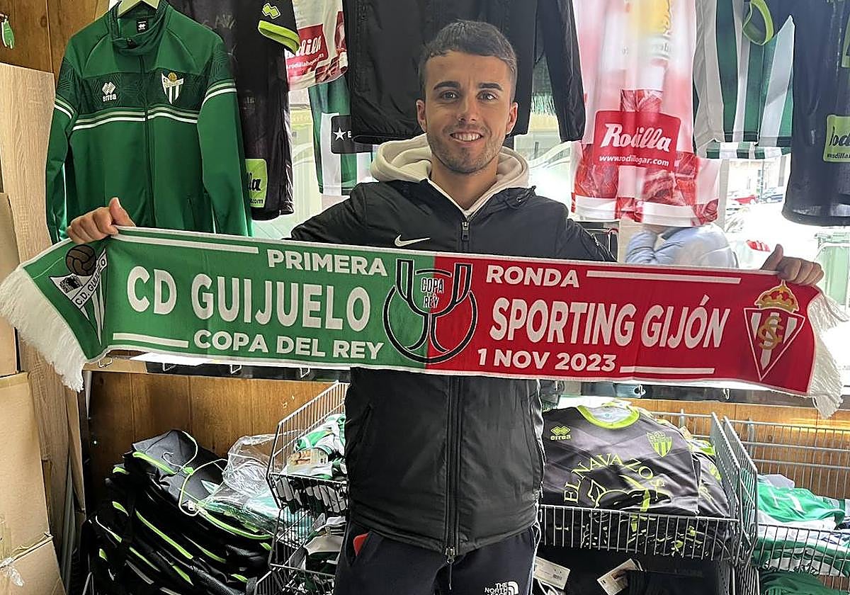Un seguidor del CD Guijuelo posa con una bufanda conmemorativa del partido.