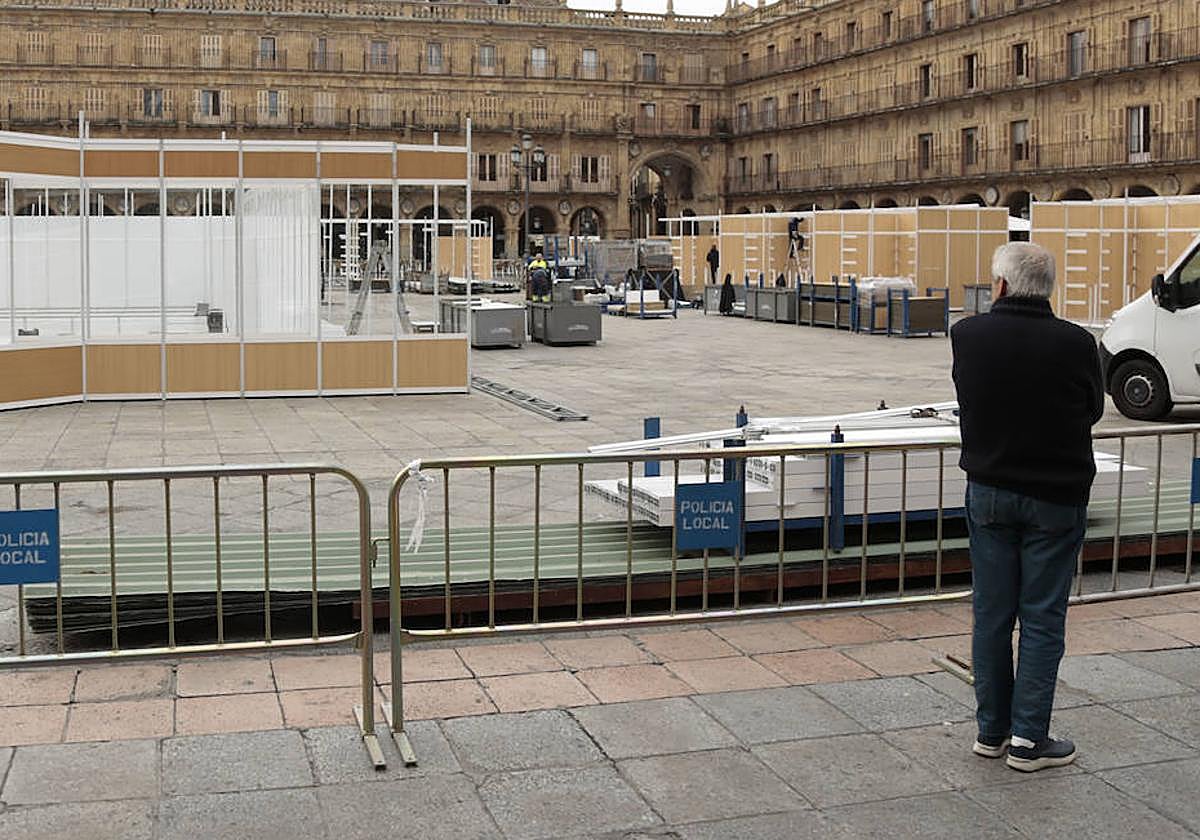 Una persona observa en la Plaza Mayor el montaje de la reciente Feria del Libro.