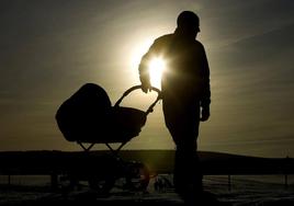Un padre pasea a su bebé, a la caída de la tarde.