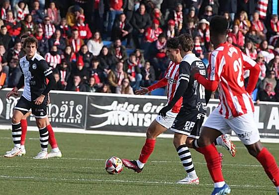 Una acción del partido con seguidores del Sporting al fondo.